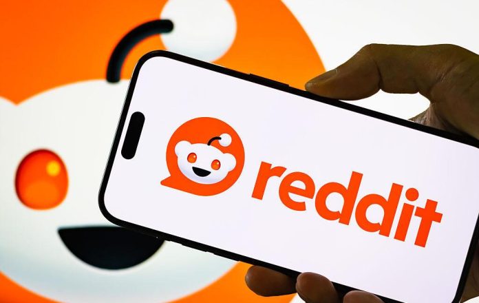 Reddit logo displayed on smartphone screen with mascot background